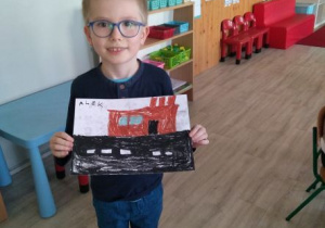 Chłopiec ze swoim rysunkiem przedstawiającym łódzką fabrykę